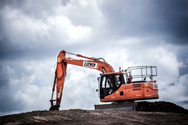 orange excavator on dirt mound
