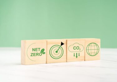 Wooden blocks showing net zero, climate goals, CO2 emissions and global climate policies.