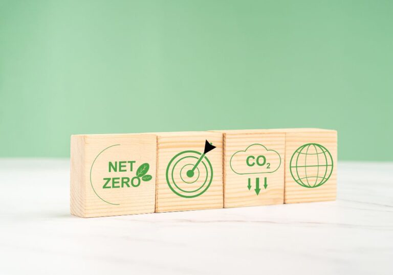 Wooden blocks showing net zero, climate goals, CO2 emissions and global climate policies.